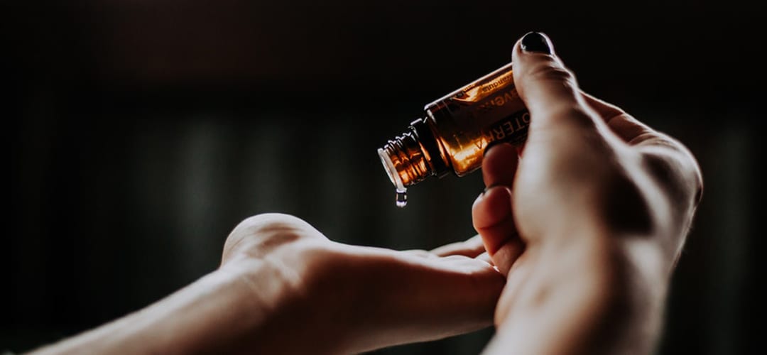 dropping essential oils in hands by christin hume